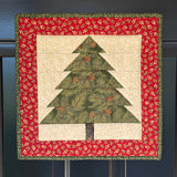 MagneQuilt Evergreen Tree mini quilt with a green pieced tree, cream background, and red holiday border.